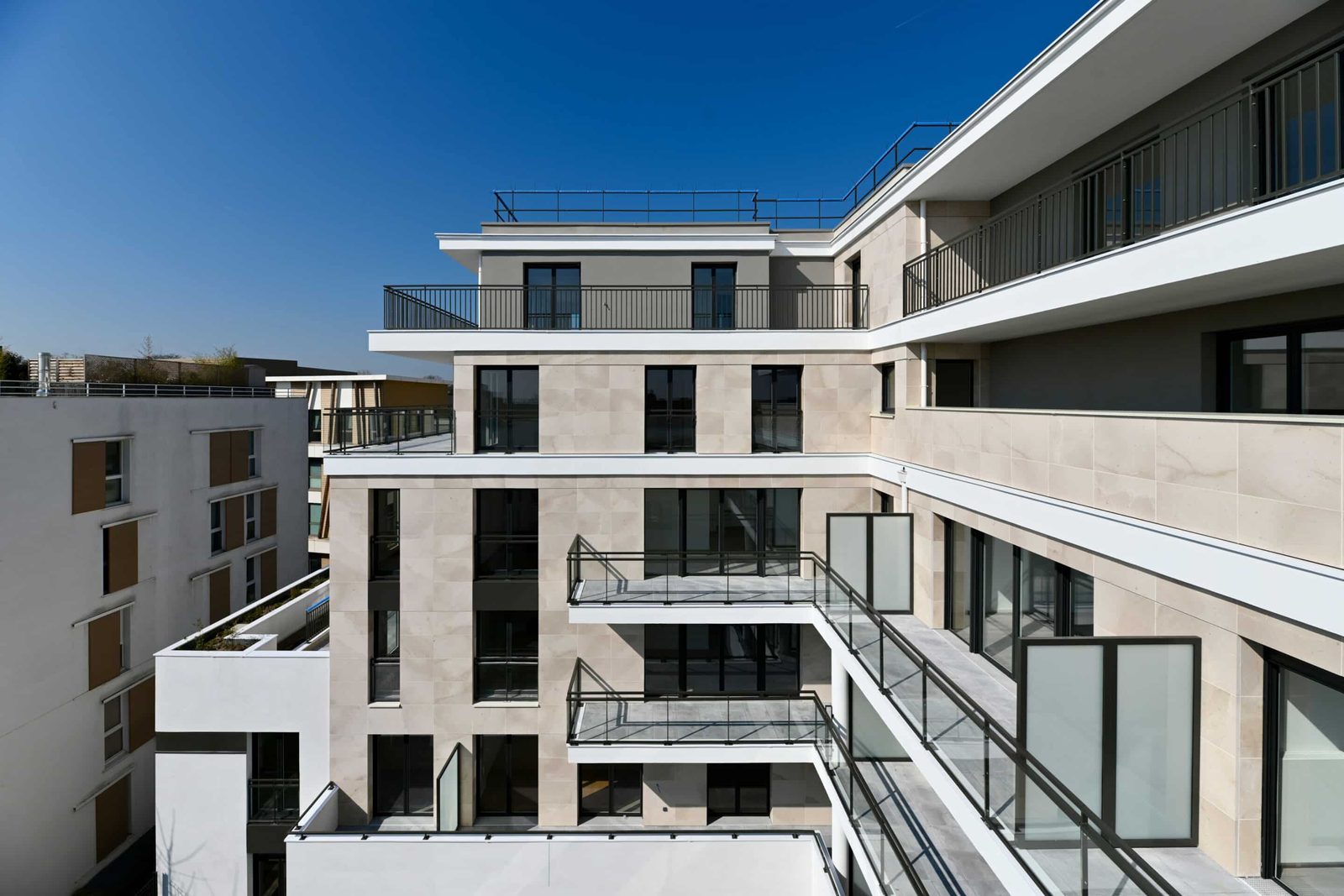 Opération Cascade, Châtenay-Malabry Façades en pierre claire et terrasses filantes de l'opération Cascade à Châtenay-Malabry, sous un ciel bleu
